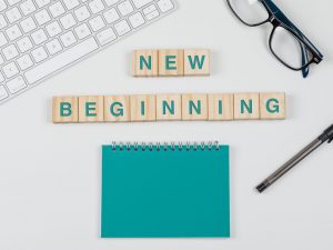 New start and business concept with wooden blocks, glasses, keyboard, pen, notebook on white background flat lay.